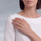 Round Emerald Solitaire Ring in Textured 18K Gold on model